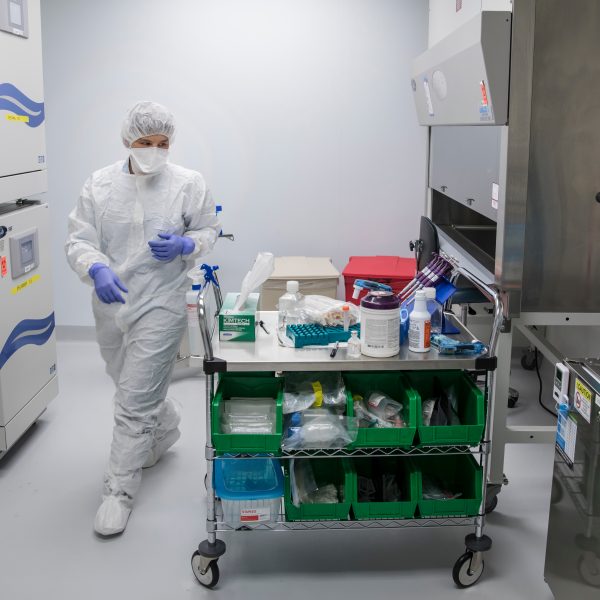 Person in a cell culture room with cart of tools