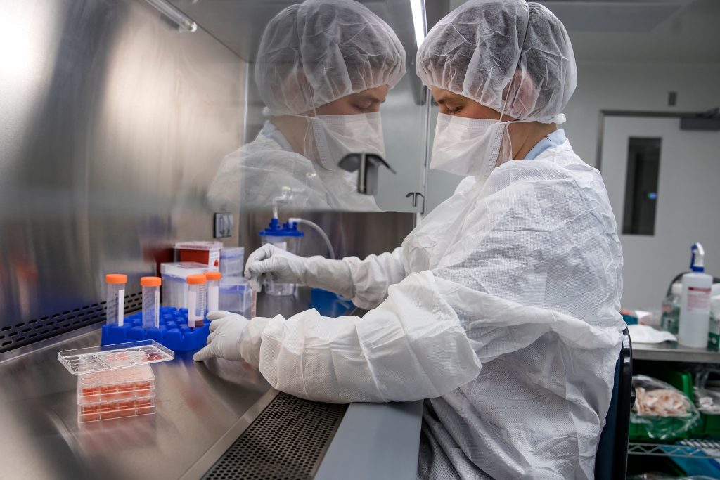 Person in a protective garments working with cell culture media