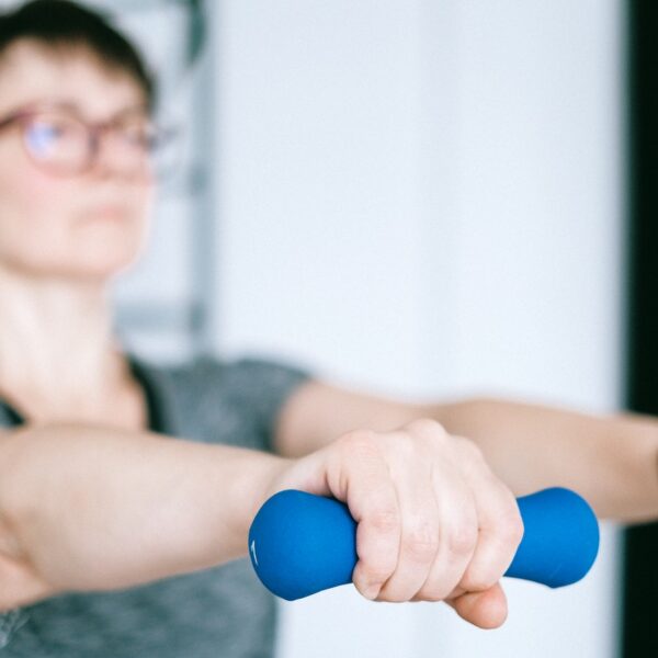 Person holding small hands weights with arms outstretched