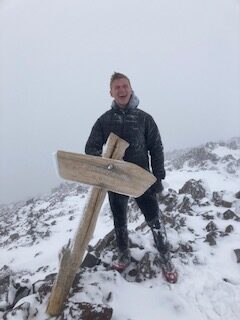 Noah Clifford on a snowy mountain peak