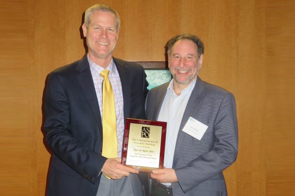 Peter Shields, MD, president of the American Society of Preventive Oncology, (right) presents Kurt Ribisl, PhD, with a plaque comemorating the honor at ASPO's annual meeting.