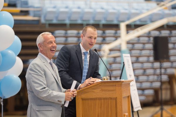 Coach Roy Williams enjoys a laugh with Jones Angell during the live auction.