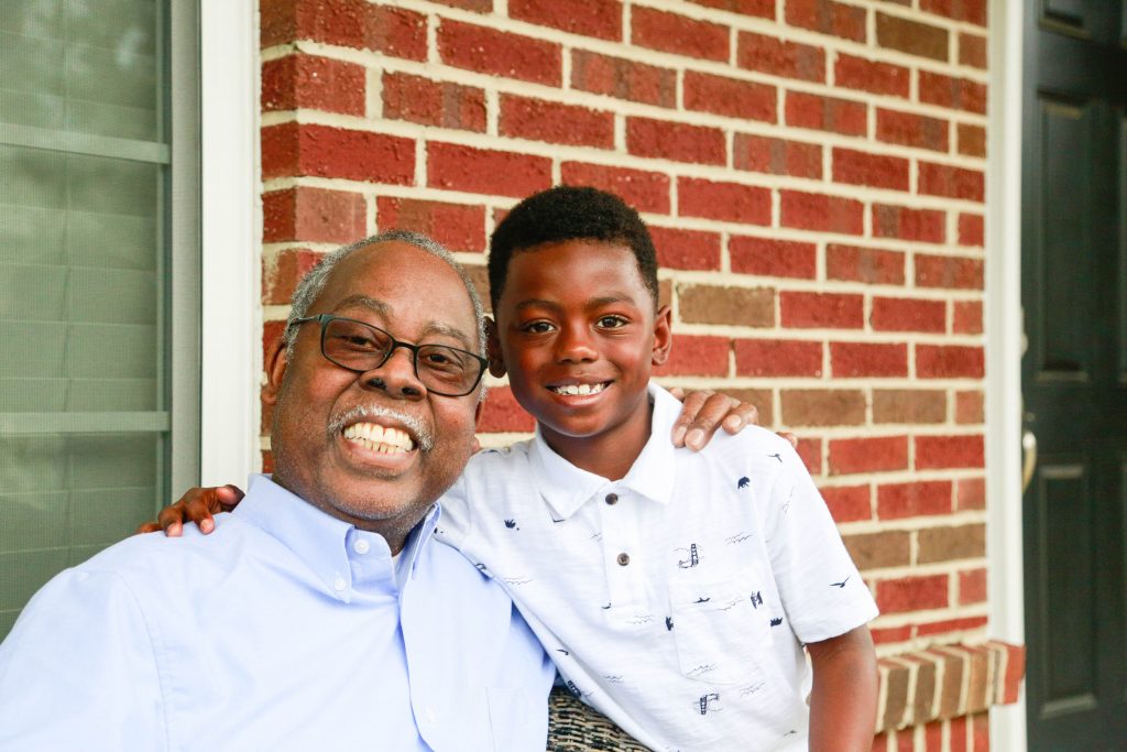 Bryson Mittman, right, sits with his grandfather, Gilbert Casterlow, Jr., PhD. For the past two years, Bryson decided that instead of birthday presents, he wanted people to donate to UNC Lineberger to help people like his grandfather.