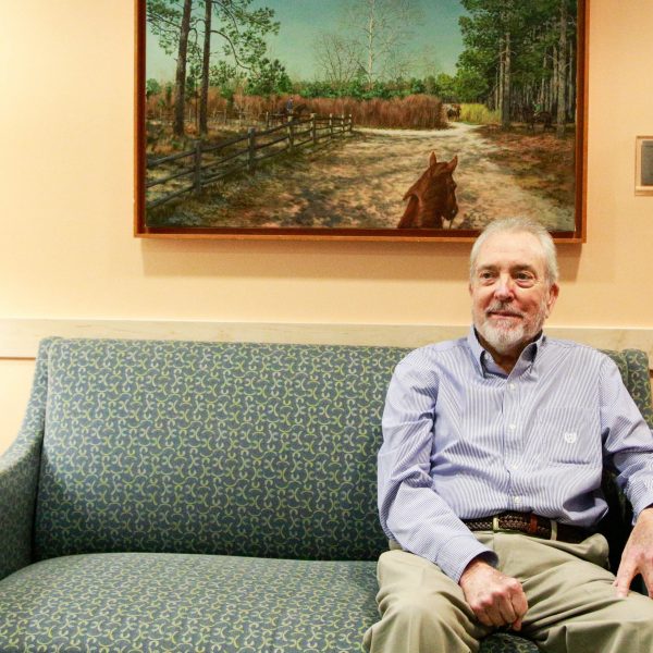 Ken Johnson sits on a green sofa in a room in the N.C. Cancer Hospital