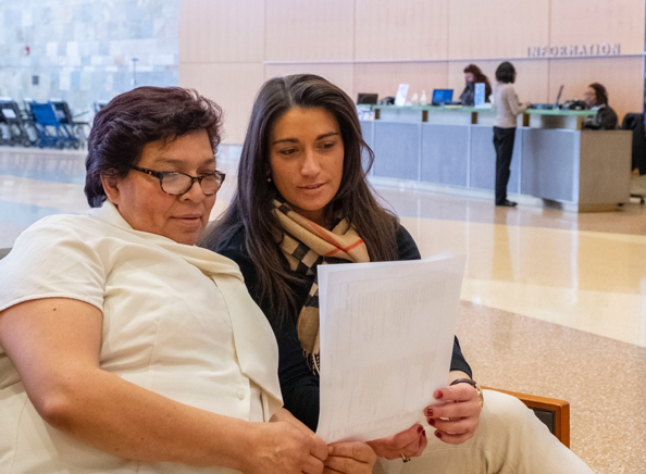 A patient and their caregiver review materials together in the lobby of the cancer hospital.