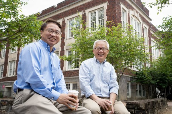 Jianping Lu and Otto Zhou sit outside of a building on the UNC-Chapel Hill campus.