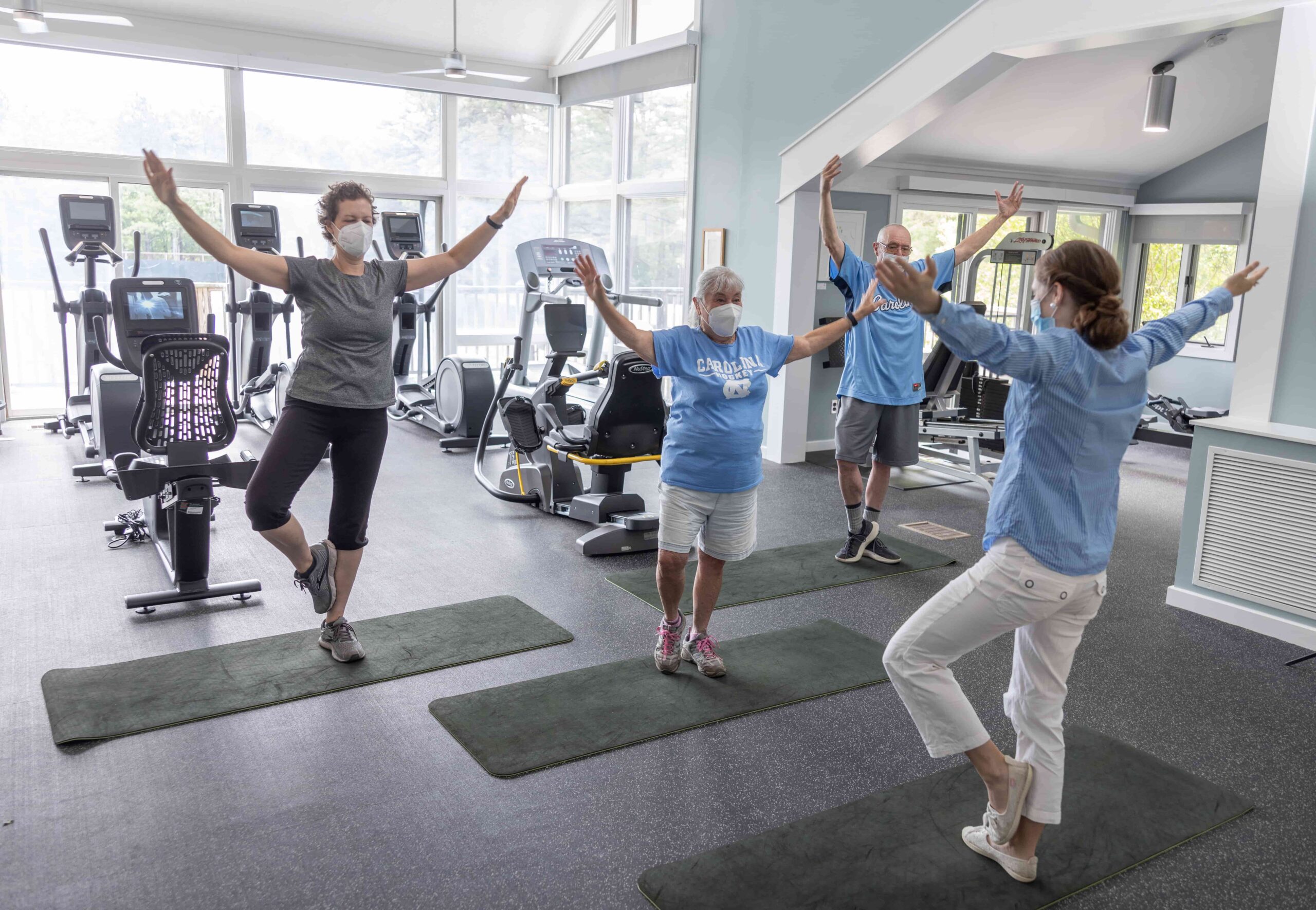 Patients work with a trainer to hold yoga poses