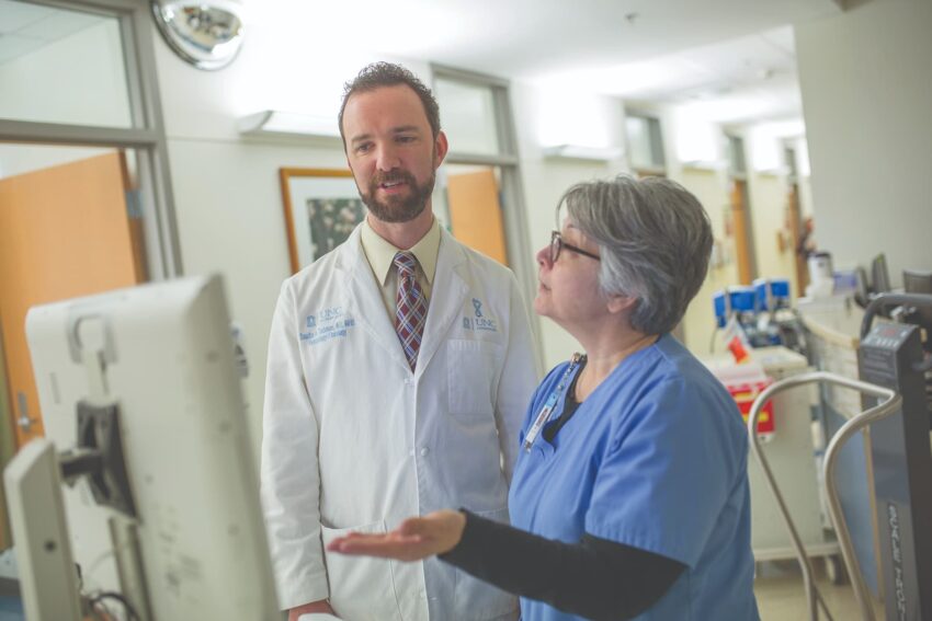 Physician Sascha Tuchman reviews a patient's chart with a nurse
