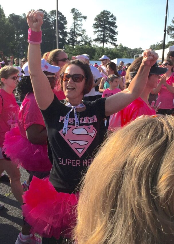 Tracey Roberson pumps her fists in the air at a breast cancer awareness walk.