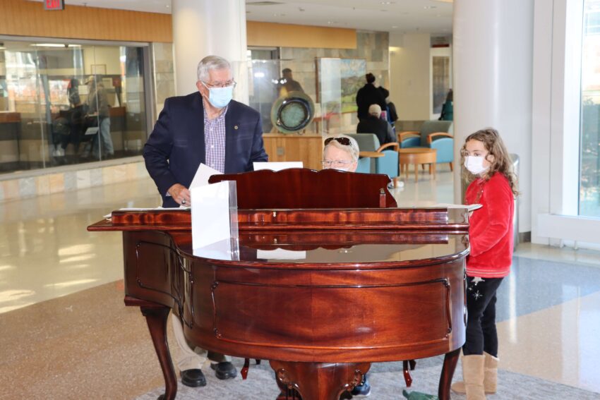 Mary Ann Van Pelt playing the baby grand piano in the hospital lobby.