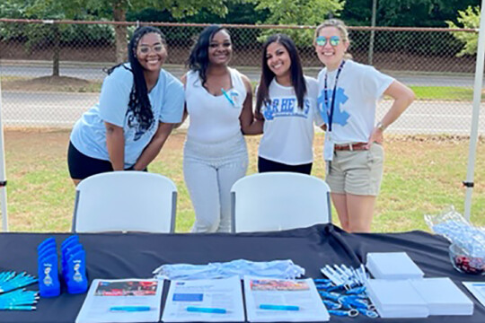 Three NCCU students and a UNC Lineberger faculty member at a health fair