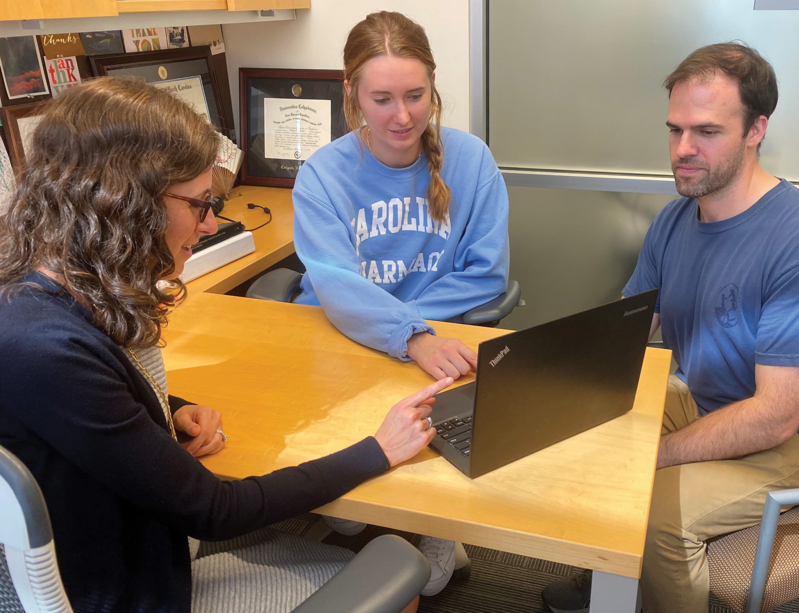 A group of three people collaborating on a laptop