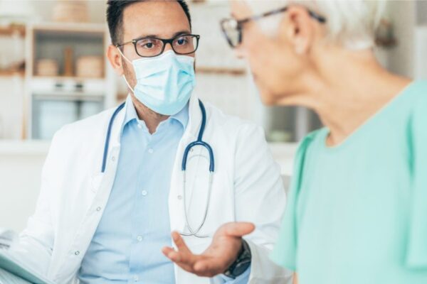 A physician talks with a patient