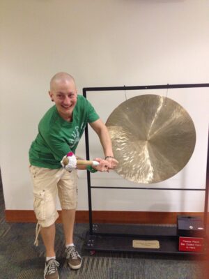 Janine Jones ringing a gong signaling the end of chemotherapy treatment.