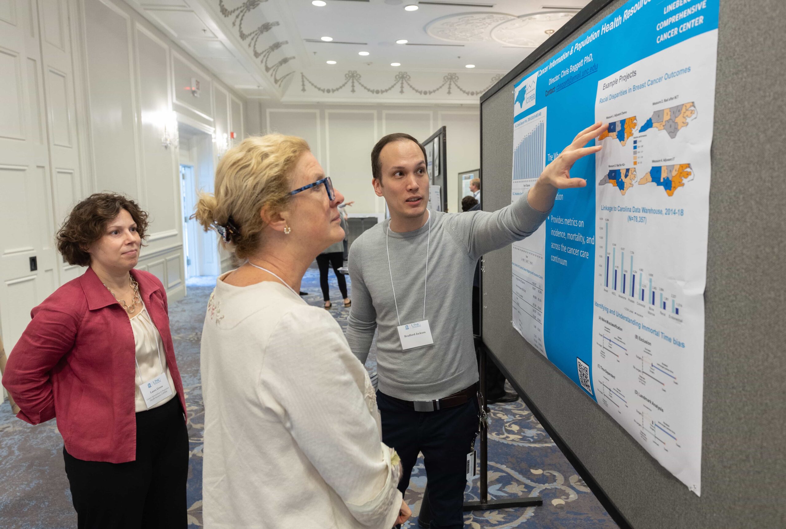 Three people gather around a scientific poster and discuss the CIPHR shared resource facility