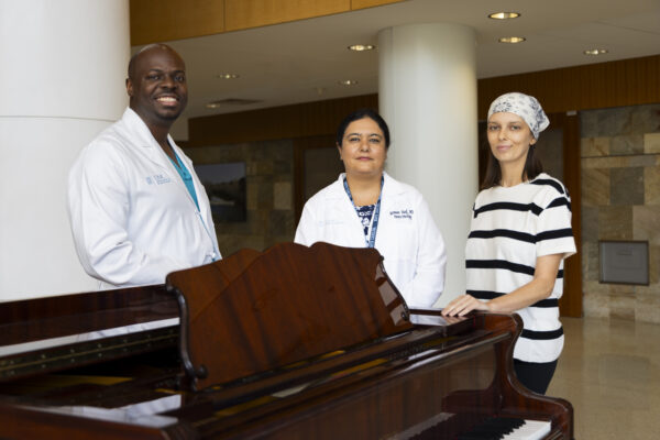 Cancer patient Hanna with doctors Dominique Higgins and Yasmeen Rauf in the lobby of the cancer hospital.