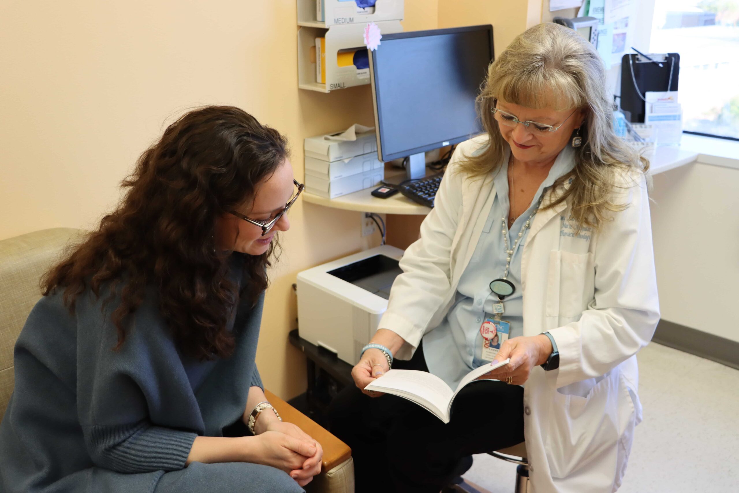 Nurse navigator Tammy Allred reviews information with a patient in the clinic.