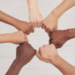 Seven arms in a circle with a diverse range of skin tones.