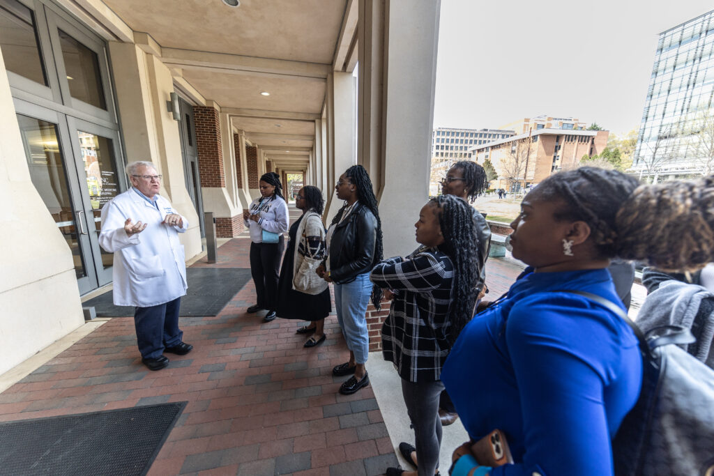 Students gather outside of a health sciences research building while on tour of cancer research facilities at UNC-Chapel Hill.