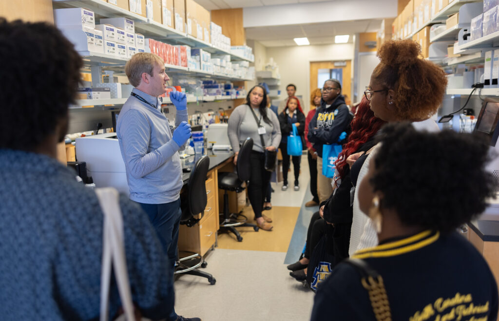 Translational Genomics Lab Director Adam Pfefferle talks to students about the genomics research in the facility.
