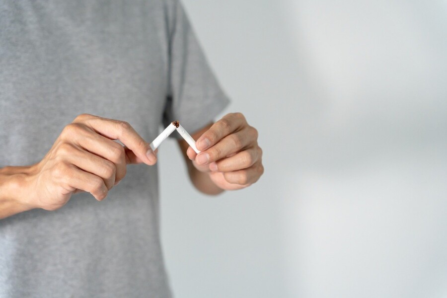 A person breaking a cigarette in half.