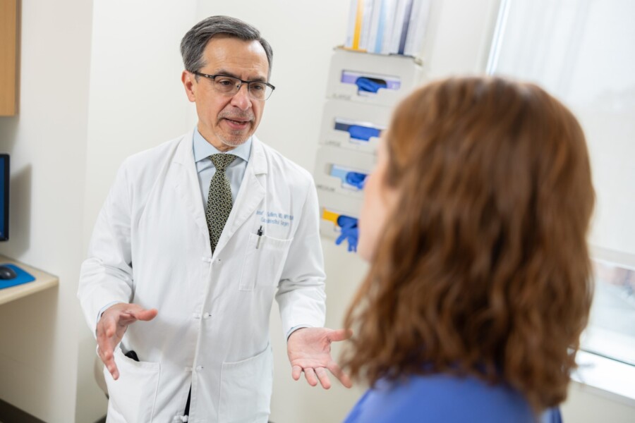 A gastrointestinal surgical oncologist meets with a patient in a clinic room.