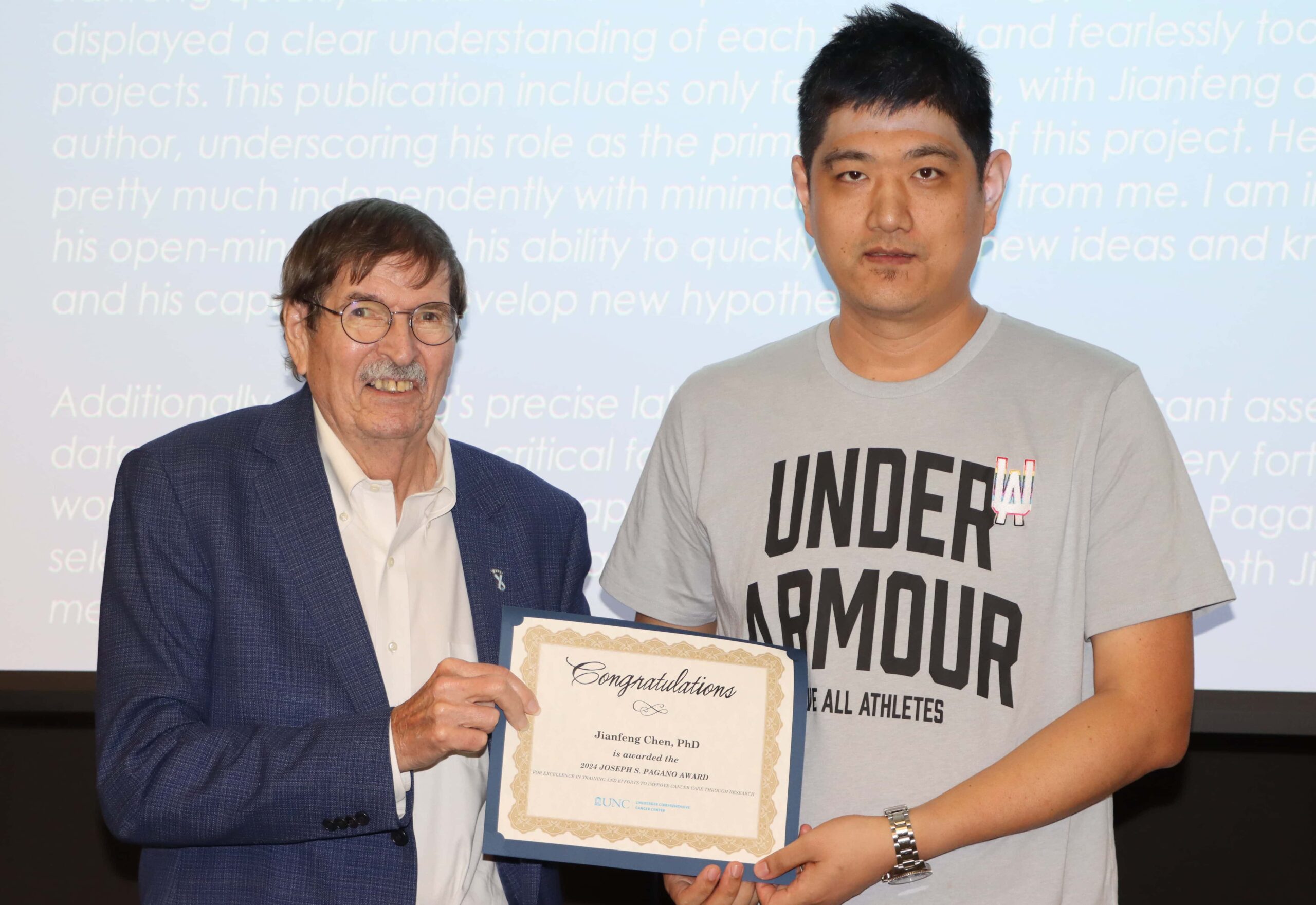 Jianfeng Chen receiving a certificate from cancer center director Shelley Earp.