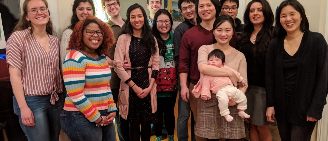 Lab Members from Yeh lab are standing together and smiling at the camera. They are dressed in warm clothes, with some holiday-themed sweaters and socks.
